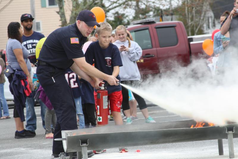 Dylan Connell, 11, of Wareham learns how to properly use a fire extinguisher from Matt Bennett at Sunday’s open house. BY MATTHEW BERNAT